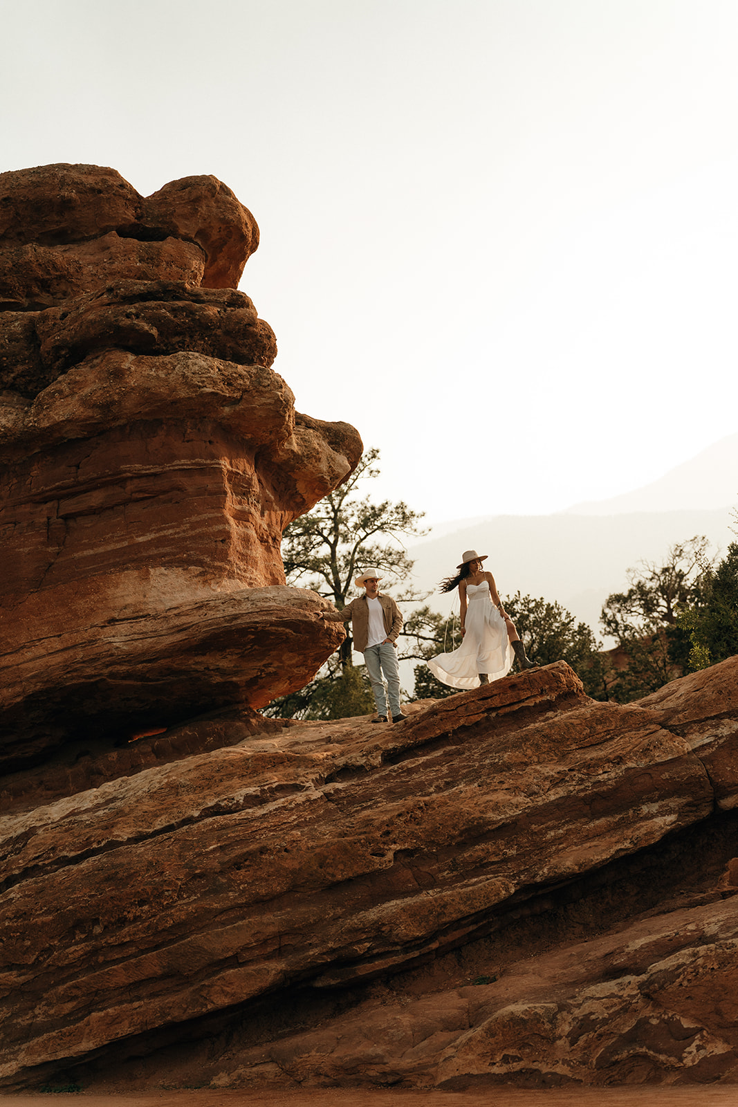 Destination Wedding and Elopement Photographer | Aisha Lee Photography Cinematic Wedding Photographer | A couple stands on rocky terrain amid large rock formations.