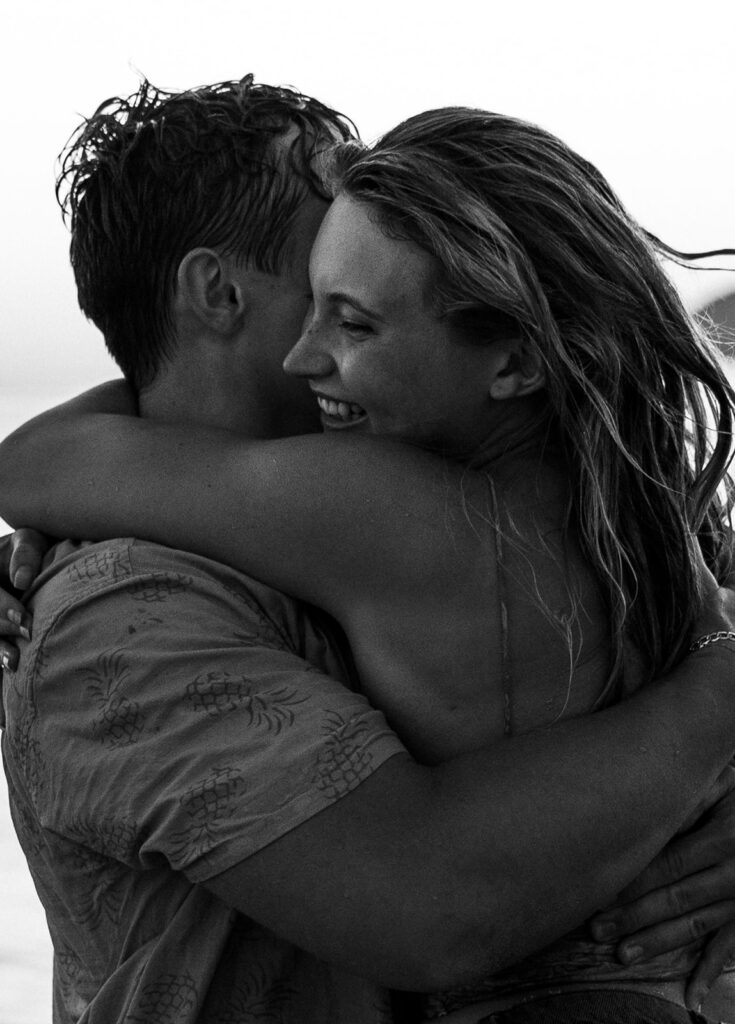 Adventure Wedding and Elopement Photographer New England | Aisha Lee Photography Cinematic Wedding Photographer | A black-and-white photo of a couple embracing closely. The woman is smiling widely,