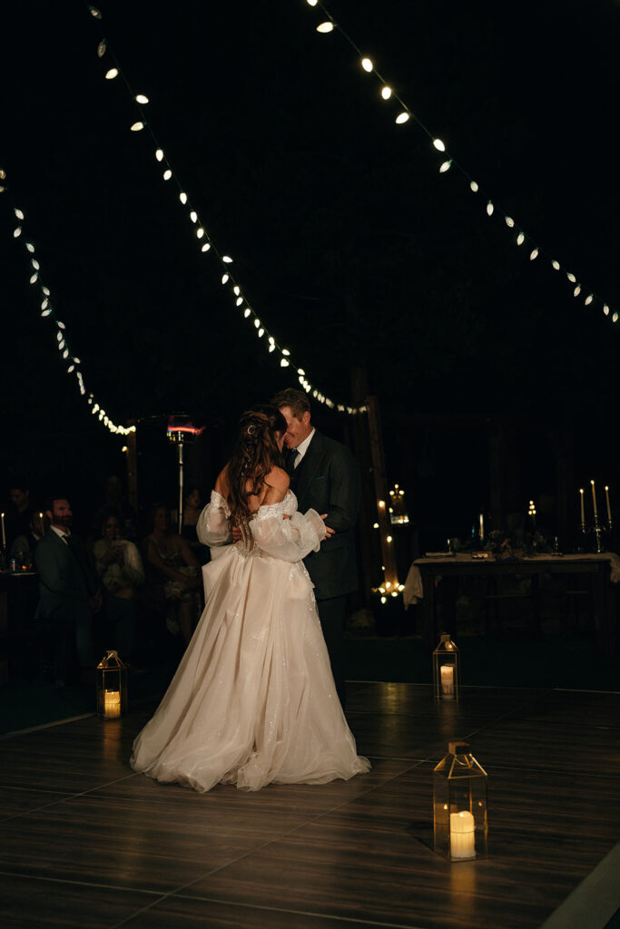 Cinematic Wedding Photographer Rhode Island | Aisha Lee Photography Cinematic Wedding Photographer | A couple shares a romantic dance on a dimly lit outdoor dance floor. They are surrounded by string lights and lanterns